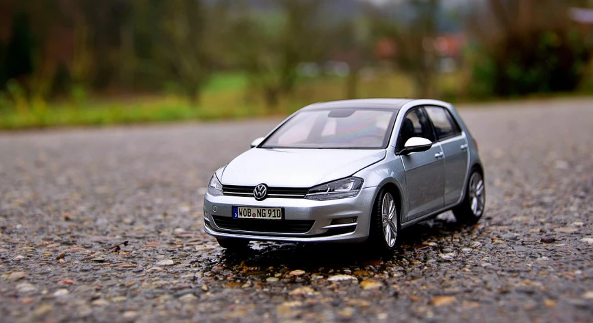 a toy car sitting on the side of a road, photorealism. trending on flickr, mercedes and volkswagen, wrx golf, photo of a model