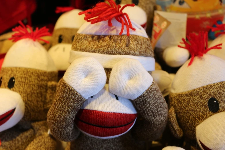 a group of sock monkeys sitting next to each other, hat covering eyes, brown, market, ultra high quality