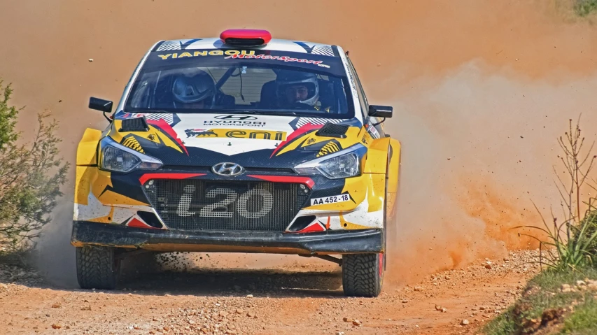 a rally car driving on a dirt road, black and yellow and red scheme, kim hyun joo, alejandro mirabal, round-cropped
