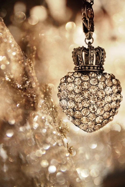 a close up of a necklace with a crown on it, a picture, tumblr, romanticism, intricate sparkling atmosphere, heart, beautiful wallpaper, swarovski and tiffany