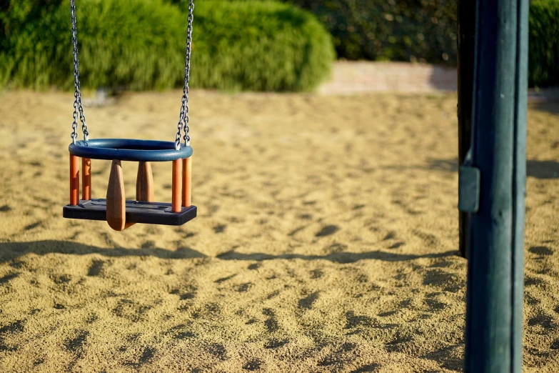 a swing that is sitting in the sand, a tilt shift photo, golden hour closeup photo, detailed zoom photo, parks and gardens, an approaching shadow