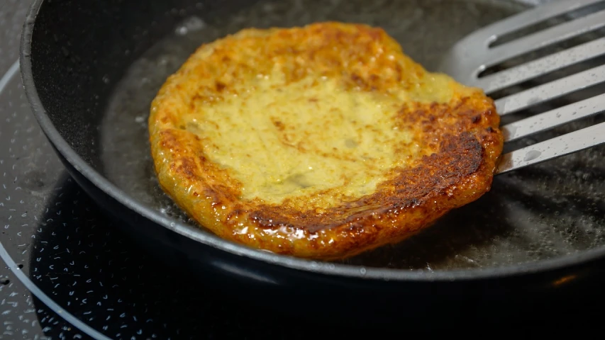 a piece of bread in a frying pan with a fork, inspired by Géza Dósa, flickr, renaissance, flan, craters, gooey skin, with celadon glaze