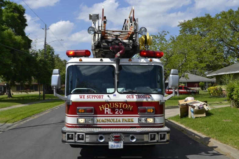 a fire truck parked on the side of the road, a photo, by Linda Sutton, shutterstock, photorealism, magnolia, texas, 3/4 view from below, b - roll