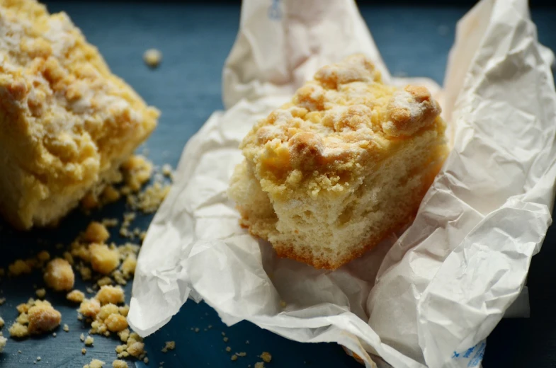 a muffin sitting on top of a piece of paper, by Dietmar Damerau, unsplash, mac and cheese, square, crispy buns, parchment