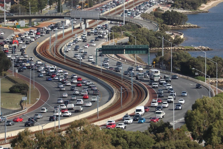 a highway filled with lots of traffic next to a body of water, by Lee Loughridge, happening, afp, in australia, usa-sep 20, associated press