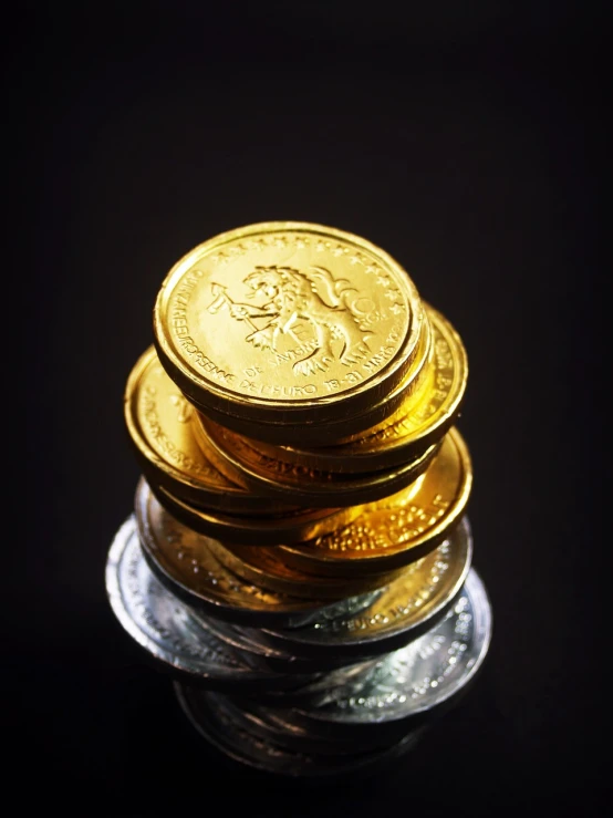 a stack of gold coins sitting on top of each other, a macro photograph, by Lee Loughridge, half lion, gold and silver, miniature product photo