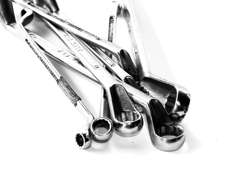 a bunch of wrenches sitting on top of each other, a stock photo, by Mirko Rački, pexels, minimalism, black on white background, empty eye sockets, polished, ( ( dithered ) )