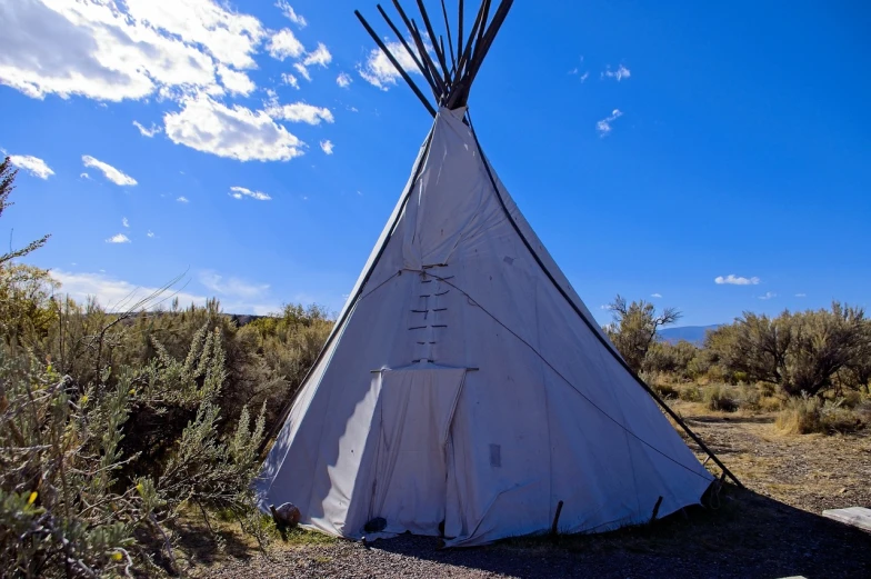 a teepee sitting in the middle of a field, on the desert, front facing view, rino, path