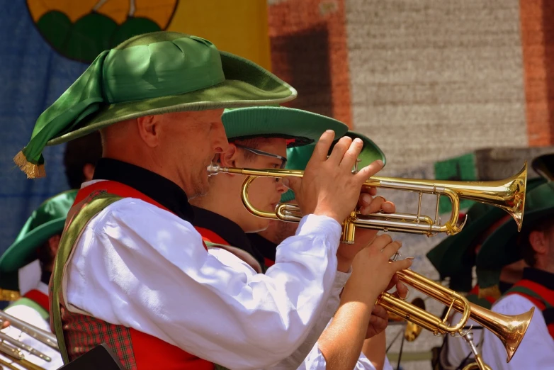 a man in a green hat playing a trumpet, a photo, by Bernd Fasching, shutterstock, couple, octoberfest, detailed zoom photo, band playing