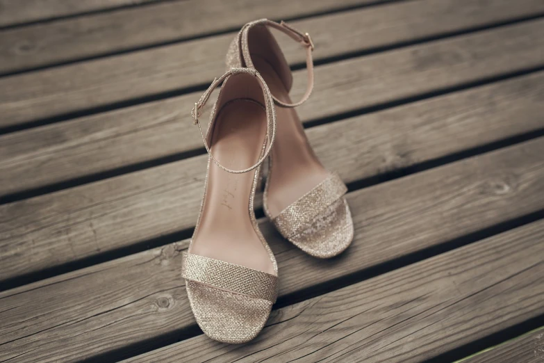 a pair of shoes sitting on top of a wooden floor, a portrait, glittery wedding, close-up product photo, sandals, finely textured