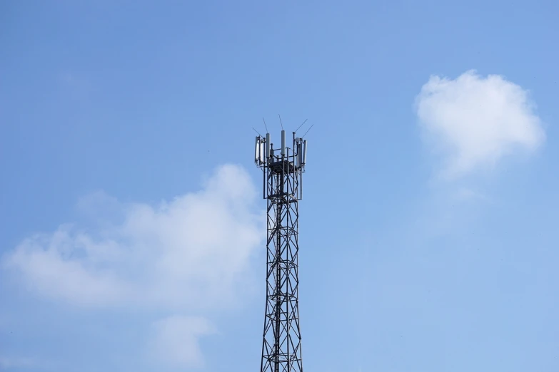 a cell phone tower against a blue sky, shutterstock, dada, 2 0 0 mm telephoto, photo taken from far away, in 2 0 1 5, slight overcast lighting