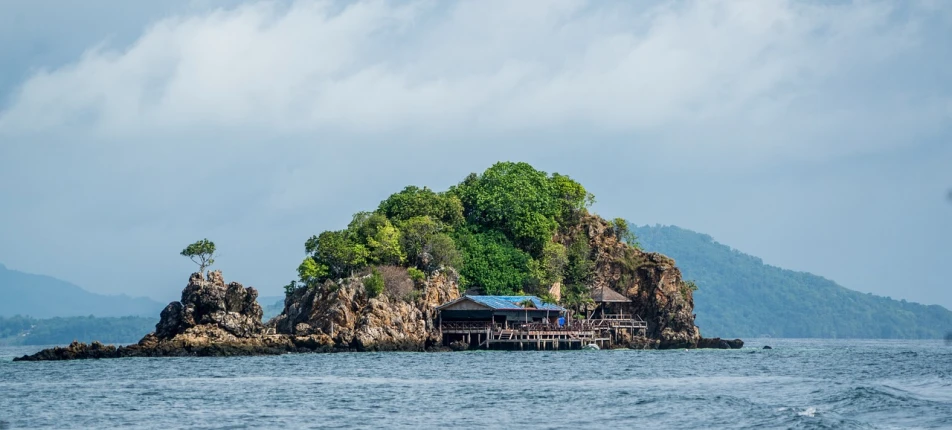 a house on a small island in the middle of the ocean, by Adam Manyoki, pixabay, sumatraism, totalitarian prison island, thai architecture, monkey island, dezeen