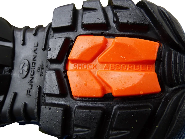 a close up of a pair of black and orange shoes, by Robert Brackman, shock art, body armor, silicone patch design, helmet view, mud