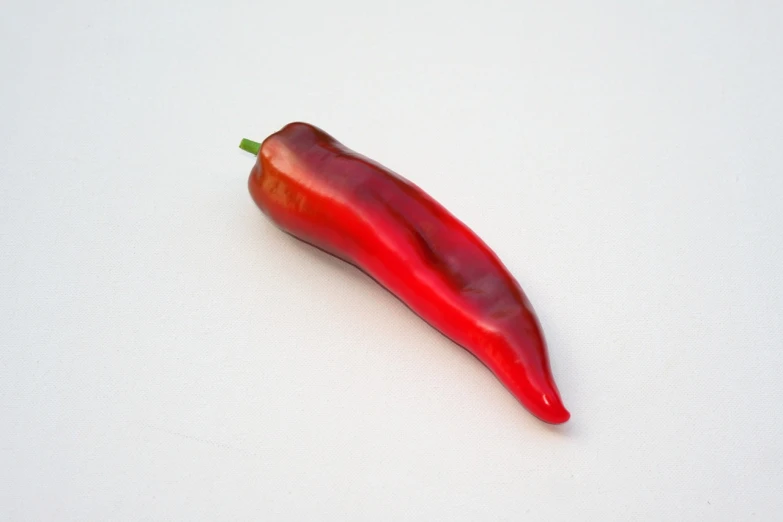 a red chili sitting on top of a white surface, a pastel, by Juan O'Gorman, tumblr, sōsaku hanga, close-up product photo, whole-length, organic shape, new mexico