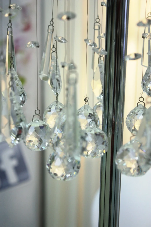 a bunch of crystal beads hanging from a mirror, 35mm, hanging tiffany chandeliers, detaling, 24 35 mm
