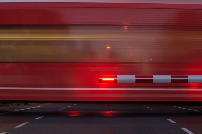 a red double decker bus driving down a street, a picture, by Hans Schwarz, unsplash, running lights, tgv, a close-up, rear-shot