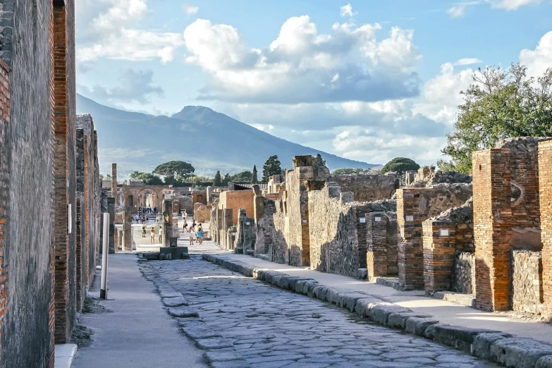 a cobblestone street with a mountain in the background, by Pogus Caesar, pixabay, renaissance, found in the ruins of pompeii, salt flats with scattered ruins, panorama of crooked ancient city, luxurious