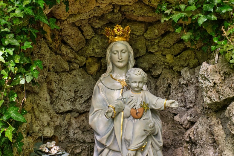 a statue of a woman holding a child, inspired by Fra Angelico, shutterstock, with crown, standing in a grotto, photo - shot, watch photo
