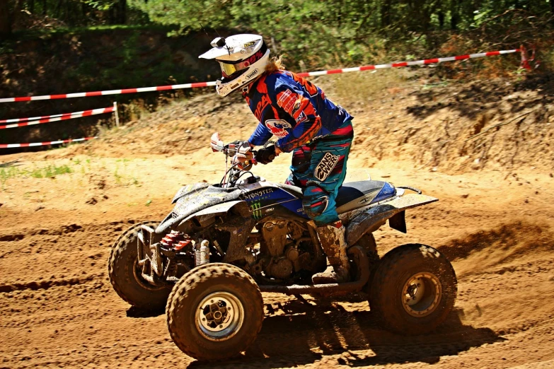 a man riding on the back of a dirt bike, a photo, all terrain vehicle race, 3 0 years woman, blue print, in a race competition