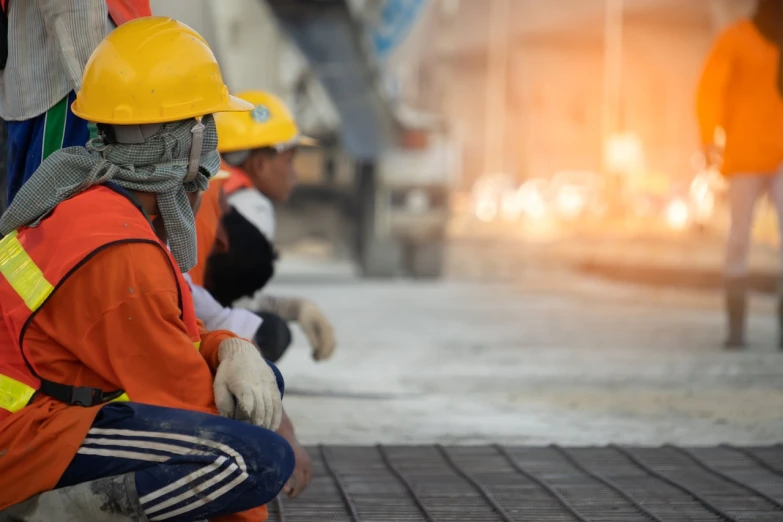 a group of construction workers sitting next to each other, a picture, shutterstock, polished concrete, slightly blurred, boy, pov photo