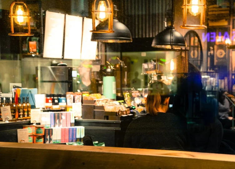 a group of people sitting at a table in a restaurant, by Richard Carline, pexels, illustrated starbucks interior, lights are on in the windows, aussie baristas, late night melancholic photo