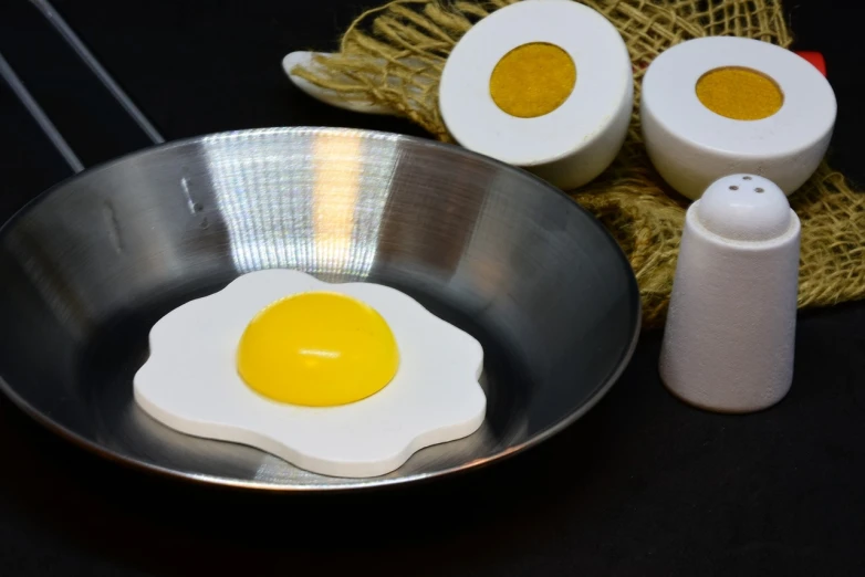 a fried egg in a frying pan next to salt and pepper shakers, trending on pixabay, dau-al-set, lot of foam, incubator medpods, listing image, cake