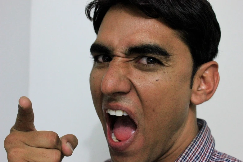 a close up of a person with an open mouth, by Daryush Shokof, flickr, angry and pointing, unibrow, fighting pose, indian