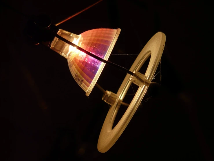 a close up of a light on a string, a hologram, by Jan Rustem, flickr, flying saucer, instrument, lamp ( ( ( gym ) ) ) ), dipstick tail