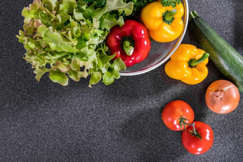 a bowl of vegetables sitting on top of a table, by Alexander Fedosav, pixabay, realism, granite, scarlet and yellow scheme, grey, pepper