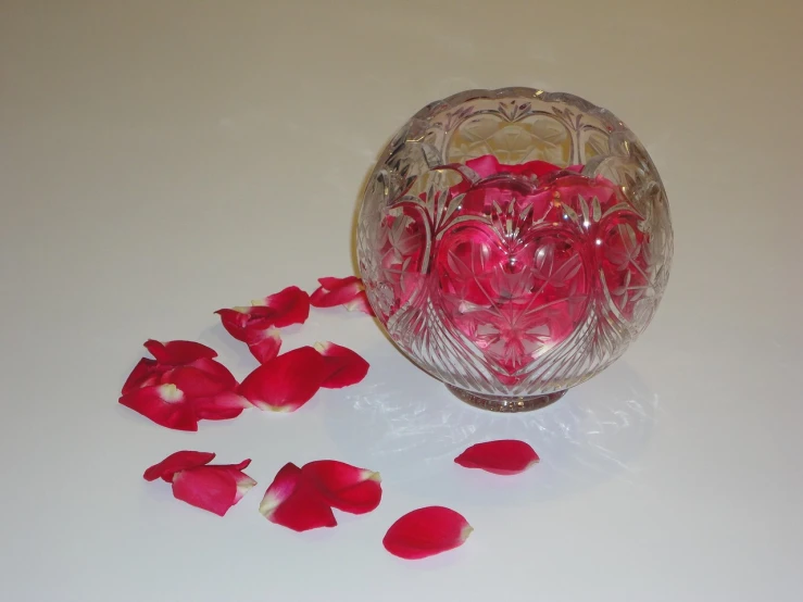 a glass vase filled with rose petals on top of a table, by Susan Heidi, process art, glass sphere, soap carving, hearts, - h 1 0 2 4