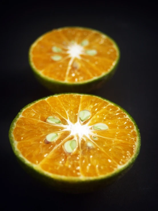 two halves of an orange on a black surface, a macro photograph, shin hanga, bright green dark orange, miniature product photo, viewed from below, half body photo