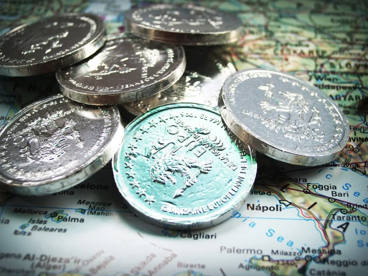 a bunch of coins sitting on top of a map, by Mathias Kollros, flickr, regionalism, shiny silver, greece, illustrative!!, detailed product photo