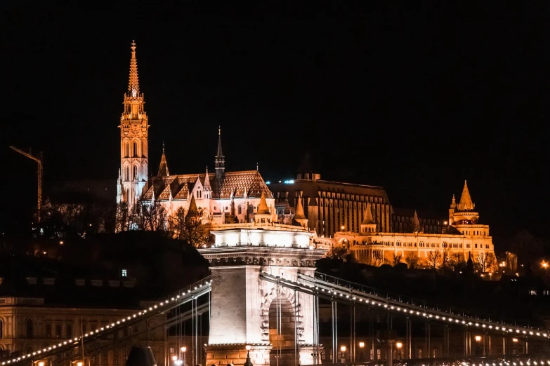 a bridge over a body of water with a castle in the background, a picture, by Adam Szentpétery, nighttime in gotham city, budapest street background, cathedral in the background, header