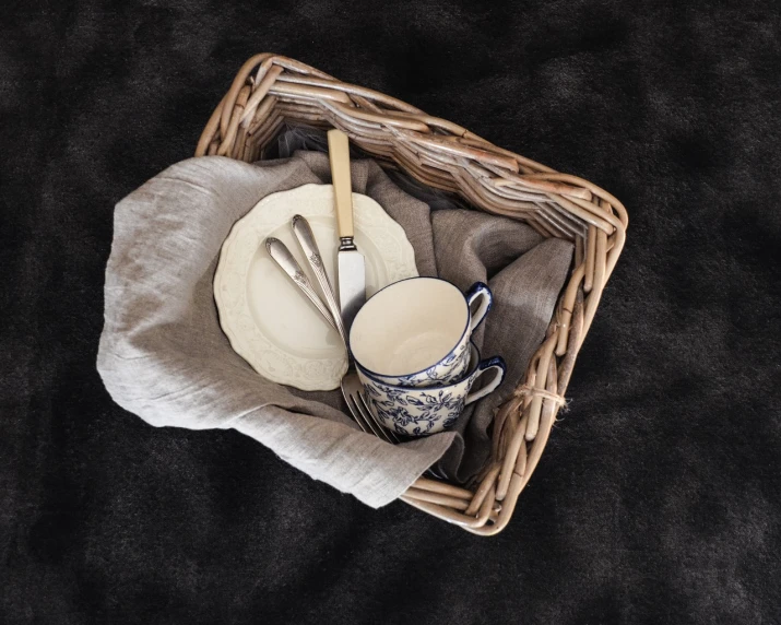 a basket filled with dishes and utensils, a still life, inspired by Wlodzimierz Tetmajer, minimalism, high detail product photo, tea party, product introduction photo