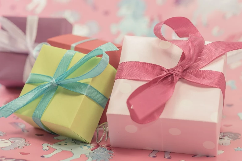 a couple of small boxes sitting on top of a table, by Rhea Carmi, pixabay, birthday wrapped presents, pastell colours, banner, promo image