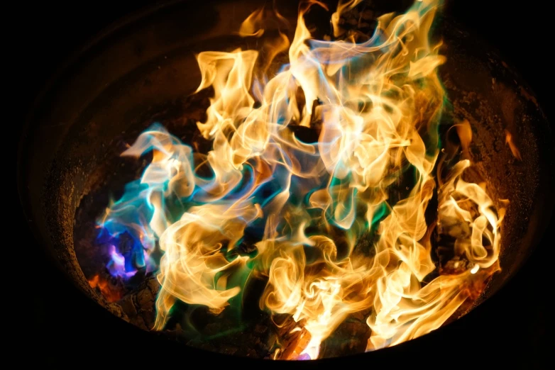 a close up of a fire in a frying pan, by Jan Rustem, shutterstock, digital art, black cyan gold and aqua colors, blue and green rainbow fire, fire pit, crown of fire