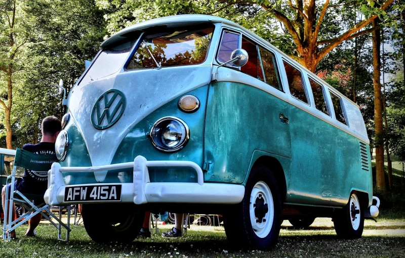 a blue and white vw bus parked on top of a grass covered field, pixabay contest winner, stained antique copper car paint, fine detail post processing, turquoise blue face, iphone photo