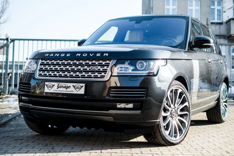 a black range rover parked in front of a building, a picture, by Thomas Häfner, shutterstock, stingray, engraved, detailed alloy wheels, highly detailed in 4k”