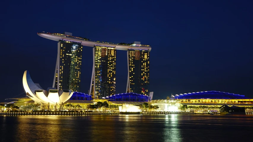 a view of a city at night from across the water, by Joseph Severn, pixabay, singapore esplanade, medium closeup shot, pavilion, stacked image