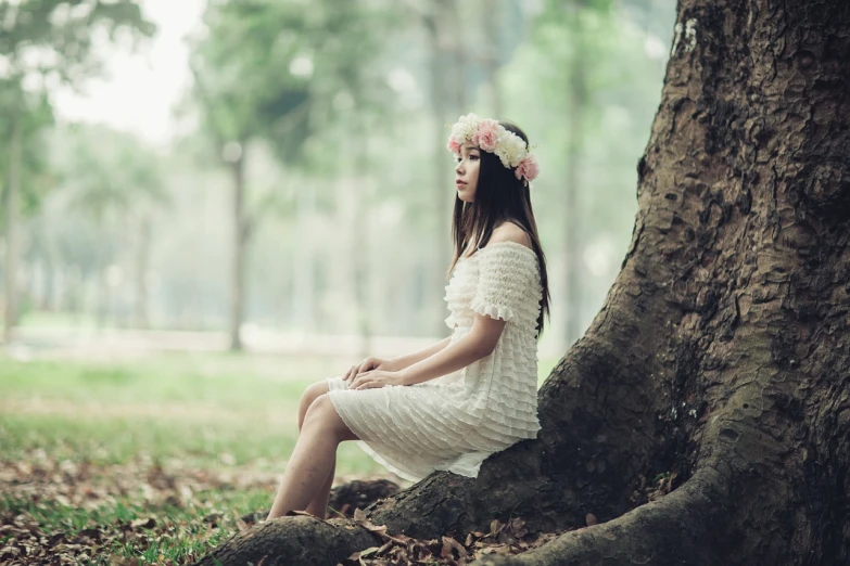 a woman in a white dress sitting under a tree, inspired by Elsa Bleda, shutterstock, wearing a headband, korean girl, girl with a flower head, 7 0 mm photo