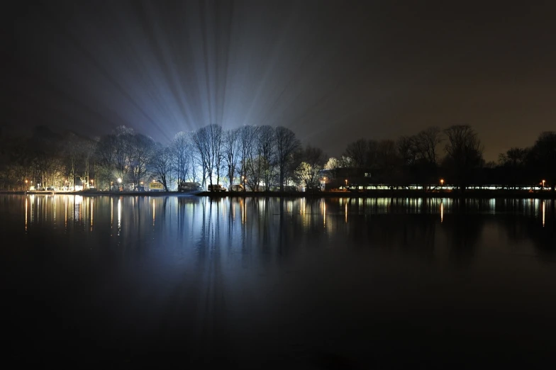 a large body of water surrounded by trees at night, a photo, by Hans Schwarz, pixabay, light and space, floodlight, hannover, brilliant cold lighting, beautiful!!!!!!!!!!!!