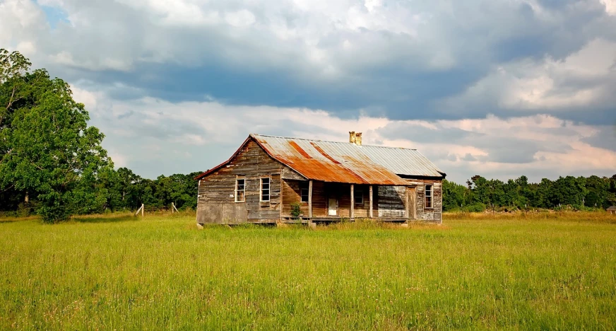 an old wooden house sitting in the middle of a field, by Adam Chmielowski, folk art, galvalume metal roofing, southern slav features, fineartamerica, 2000s photo