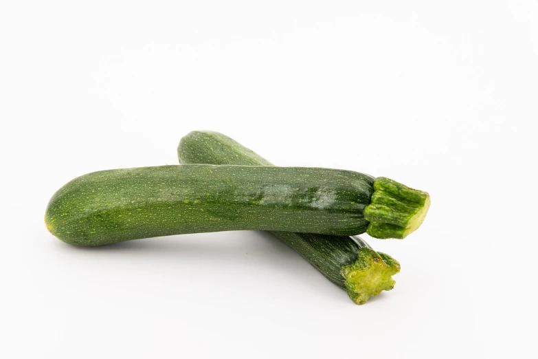 two zucchini sitting next to each other on a white surface, a picture, sōsaku hanga, half body photo, portlet photo