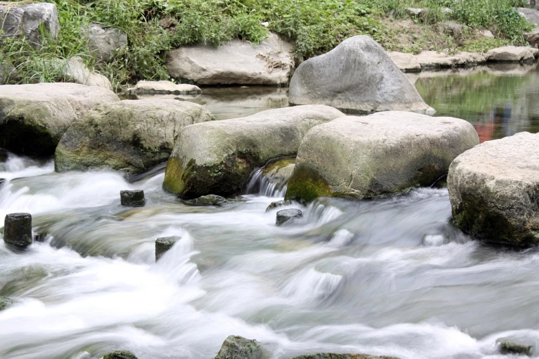 a stream running through a lush green forest filled with rocks, a picture, by Mirko Rački, closeup photo, of a river, city park, 2000s photo