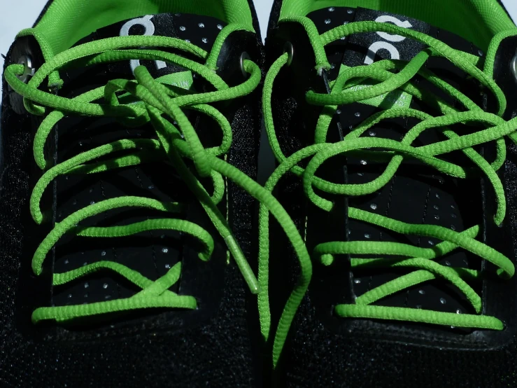 a pair of black and green sneakers with green laces, by Jon Coffelt, pixabay, intricate hyper detail, view from the bottom, fluo colors, laces