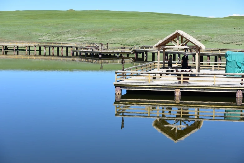 a wooden dock sitting on top of a lake, by Jim Nelson, land art, sci - fi mongolian village, hollister ranch, loosely cropped, 2 0 2 2 photo