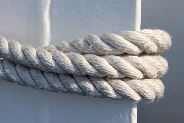 a close up of a rope on a boat, by David Simpson, modernism, white braids, detailed white, traditional medium, fade