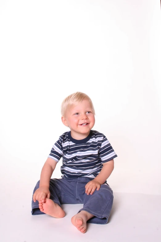 a little boy that is sitting on the ground, a picture, studio portrait photo
