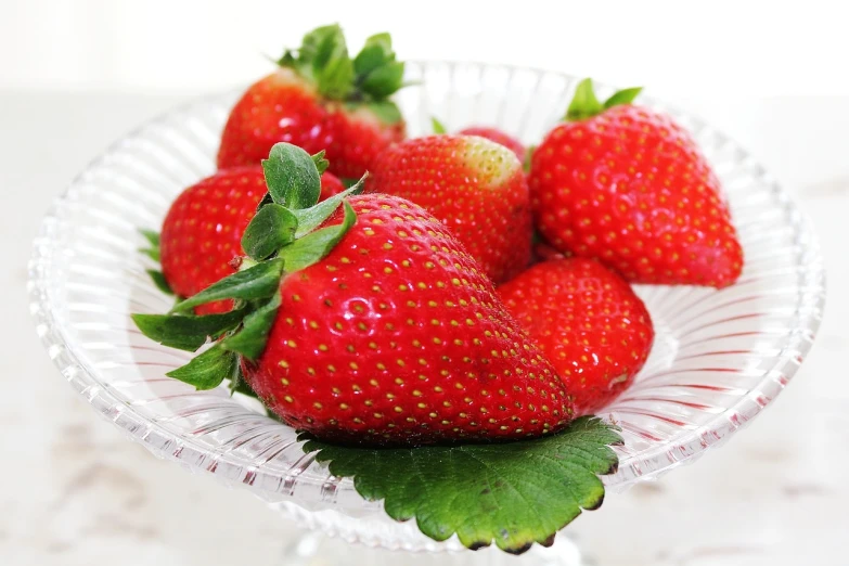 a close up of a plate of strawberries on a table, a picture, by Maeda Masao, pixabay, shin hanga, glass tableware, !!award-winning!!, grain”, white!!