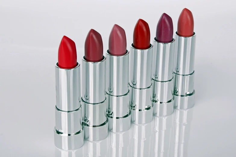 five lipsticks lined up in a row on a white surface, by John Hutton, silver red, behaelterverfolgung, qvc, modern”